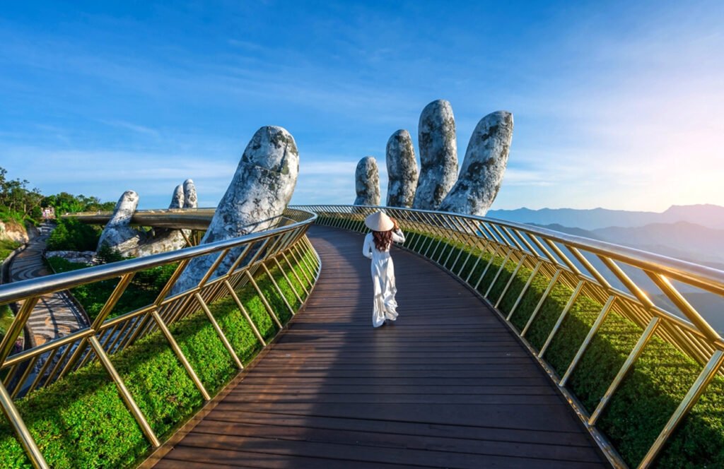 a woman walking on a bridge with a large hand shaped bridge